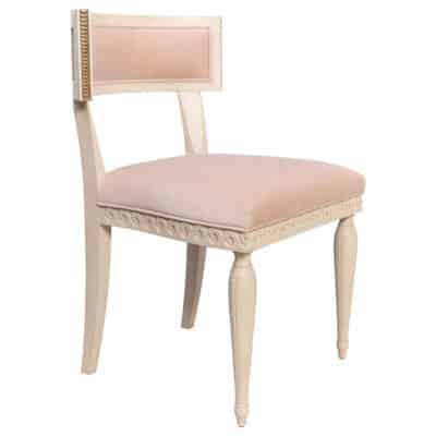 Close-up of Athena Klismos Style Chair, featuring rosewater velvet upholstery and ironstone finish with gilt carving.