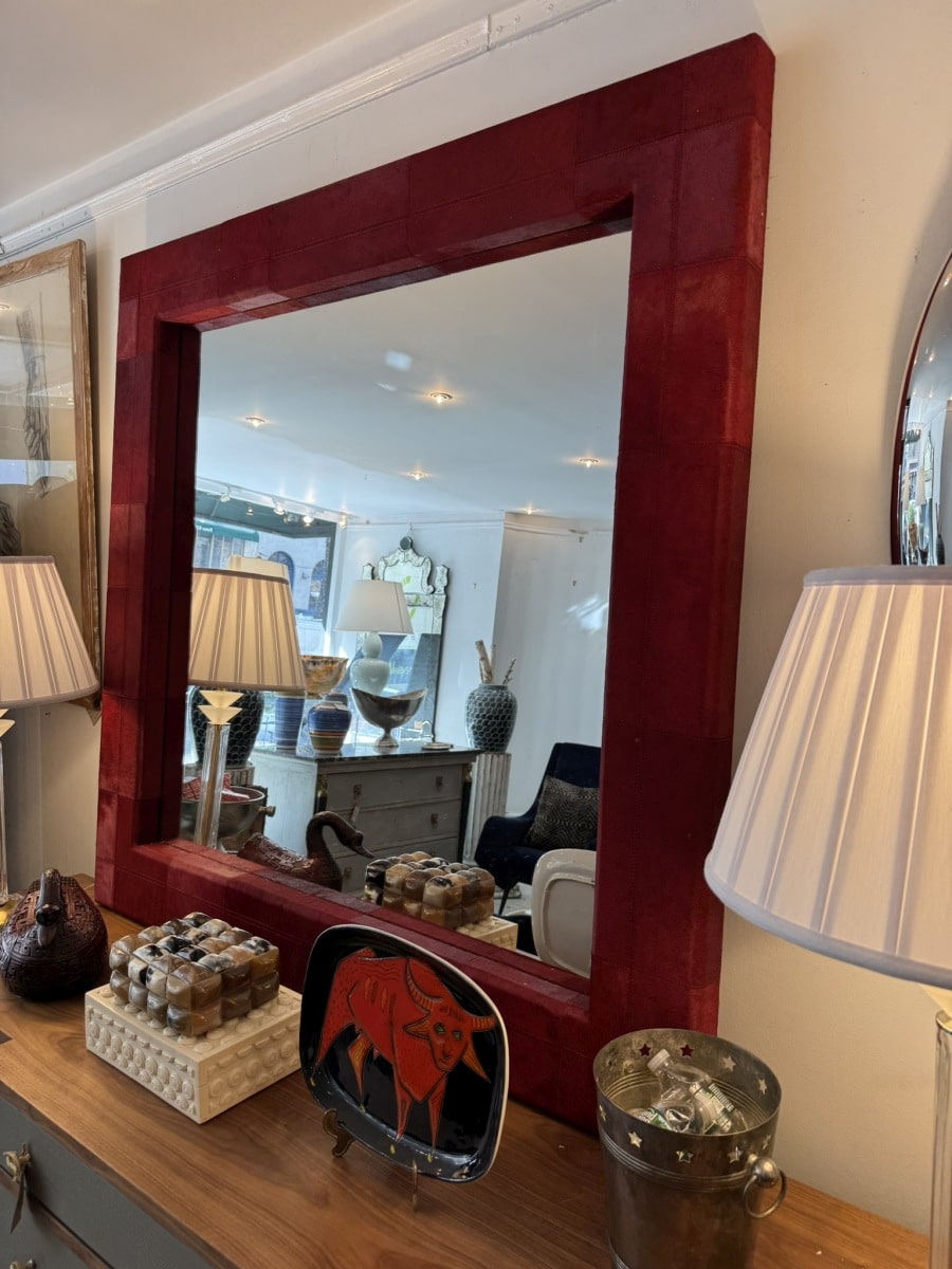 Close-up of Tauro Wall Mirror featuring vibrant red hair-on-hide design in quilted pattern with double stitch detail.