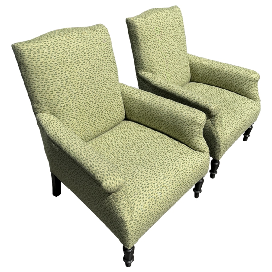 Close-up of antique chairs with rolled arms, featuring floral upholstery and nailhead detail from France in the 19th century.