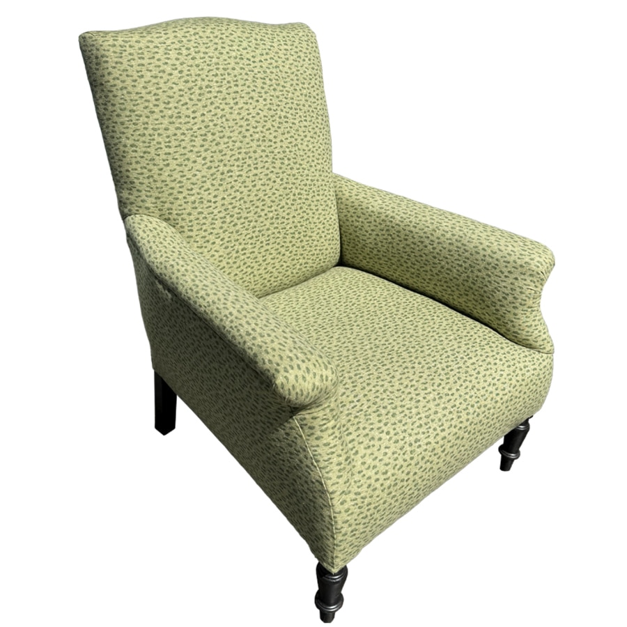 Front view of antique upholstered chair with rolled arms and nailhead detail.