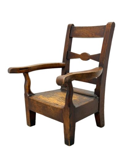 Front view of vintage English oak children's chair with aged patina, three back slats, and two curved arms.