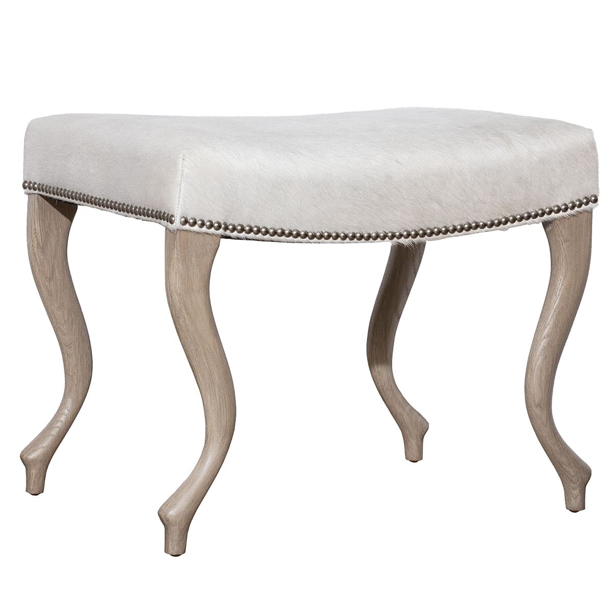 Close-up of Upholstered Hide Ottoman in Serengeti Natural Grade 7 Hide, featuring curved wood legs with platinum nailhead trim.