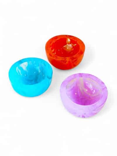 Three vibrant Lucite mini bowls in blue, coral red, and lavender.