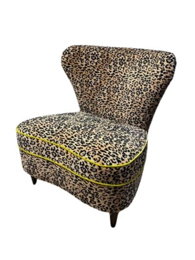 Close-up of Hourglass Animal Print Chair with Kiwi Welt, featuring bold leopard pattern and contrasting trim.