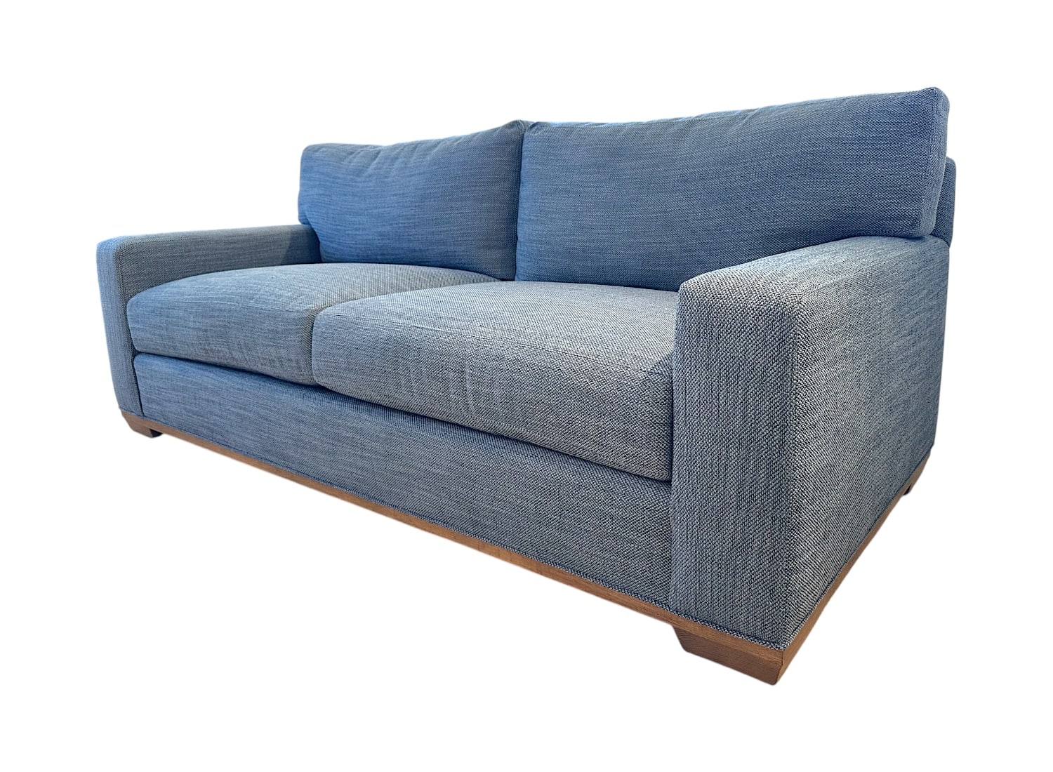 Blue upholstered apartment sofa with weathered grey legs, front view.