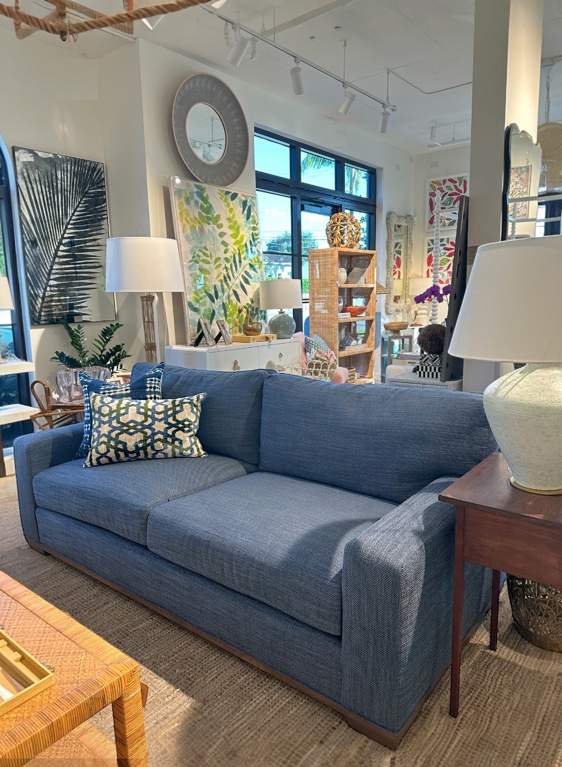 Front view of apartment sofa in blue upholstery with weathered grey legs.
