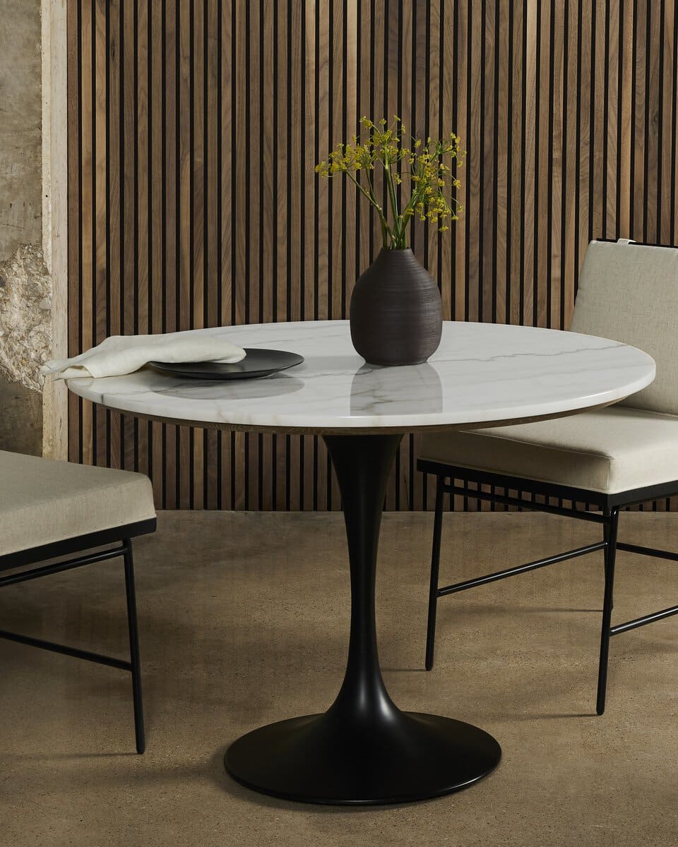 Front view of sleek Powell Marble dining table with white marble top, contrasting black iron base.