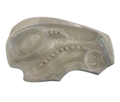 Close-up of vintage ivory ceramic ashtray with intricate design, circa 1970s.