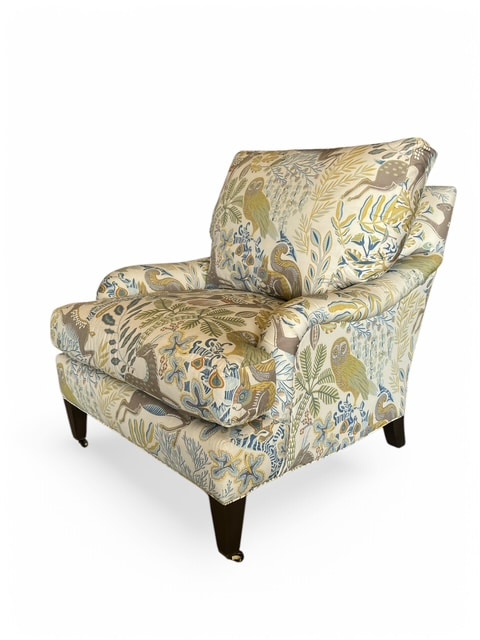 Close-up of Wonderland Fawn Arm Chair, featuring intricate fabric design on cushions and pecan finish wood legs.