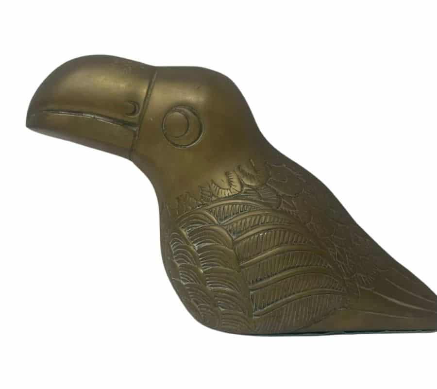 Close-up of vintage brass toucan sculpture with green felt base, showcasing intricate details and smooth finish.