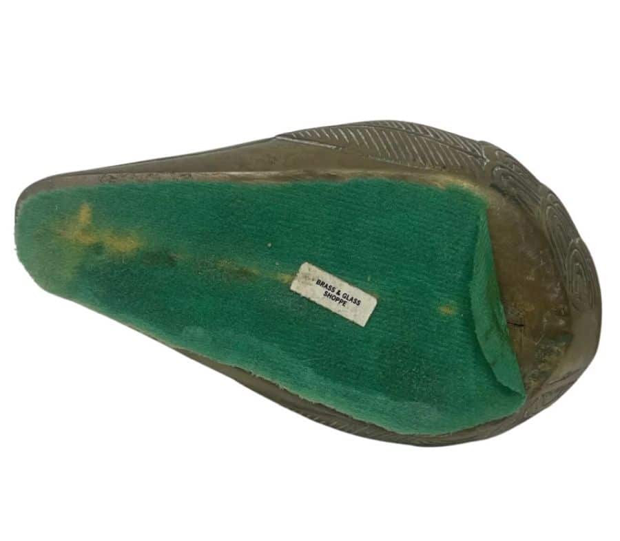 Green felt base of vintage brass toucan sculpture.