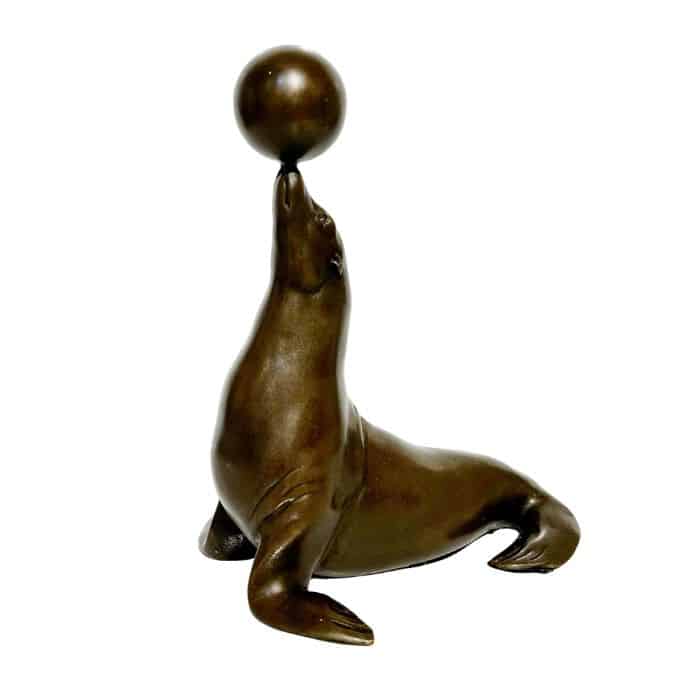 Bronzed seal figurine balancing ball on nose, vintage charm.