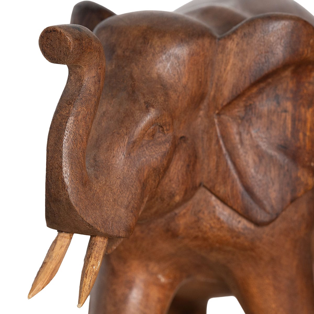 Close-up of vintage hand carved wood elephant figurine with raised trunk and two tusks, aged patina.