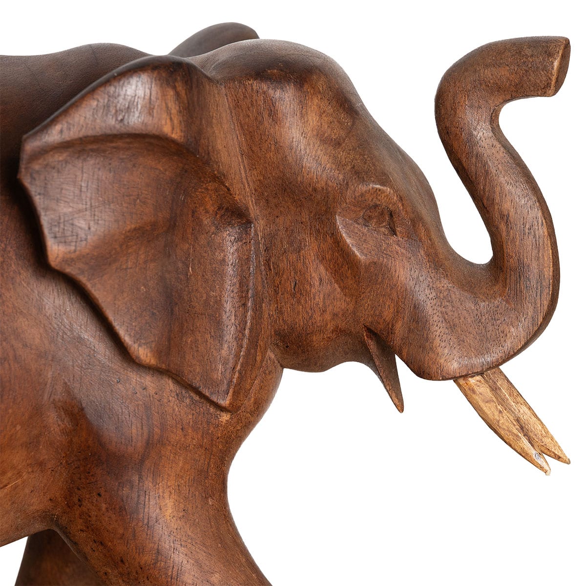 Close-up of large vintage hand carved solid wood elephant with two tusks and raised trunk aged patina with blemishes including chip on