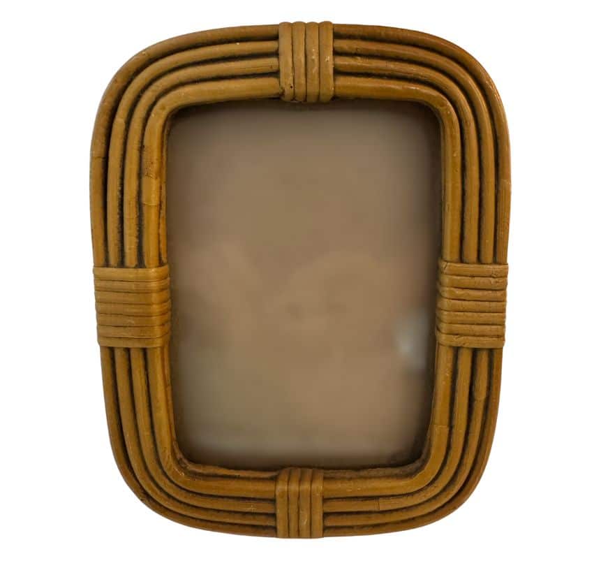 Vintage oval bamboo frame in close-up, showcasing its intricate weaving pattern and natural brown tones.