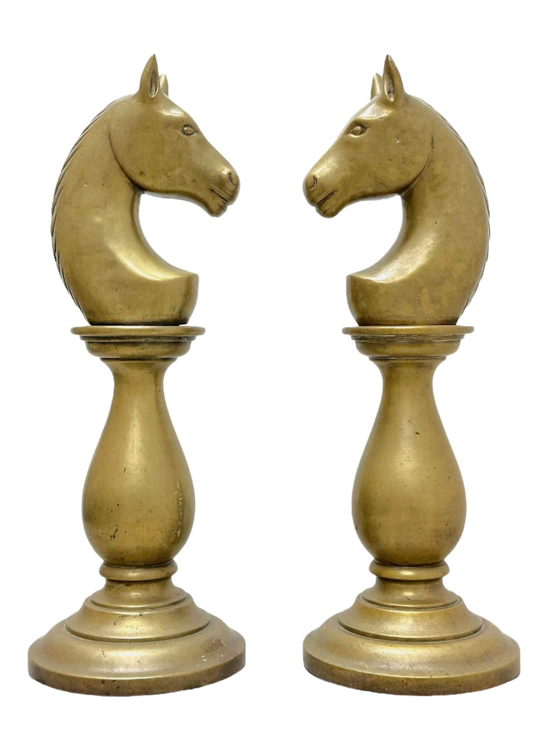 Close-up of vintage brass horse chess pieces on round bases, showcasing intricate details.