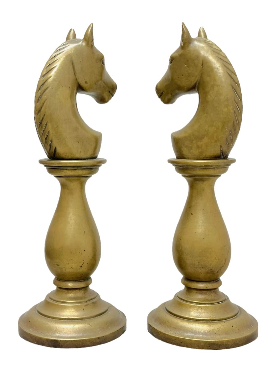 Close-up of vintage brass horse chess pieces on round bases, showcasing intricate details.