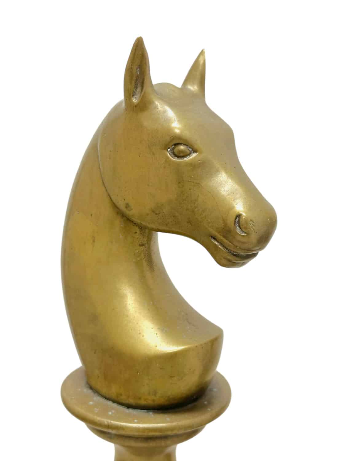 Close-up of a golden vintage horse chess piece on a round base.