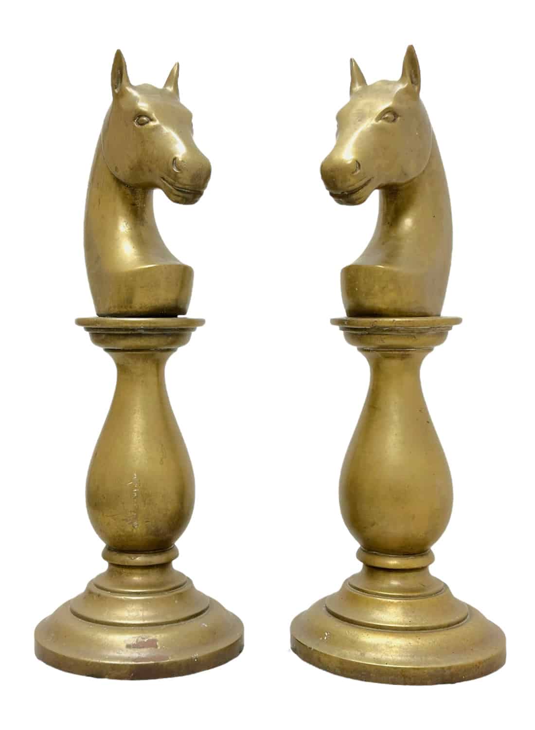 Close-up of two vintage brass chess pieces featuring horse heads on round bases, evoking an air of elegance and nostalgia.