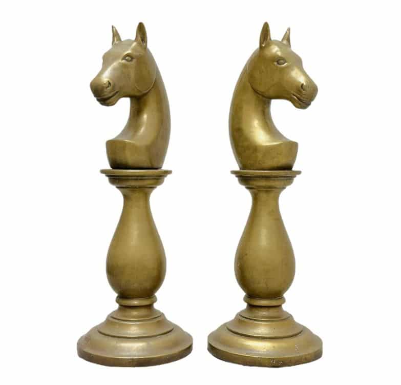 Vintage brass chess pieces, horse heads on round bases.