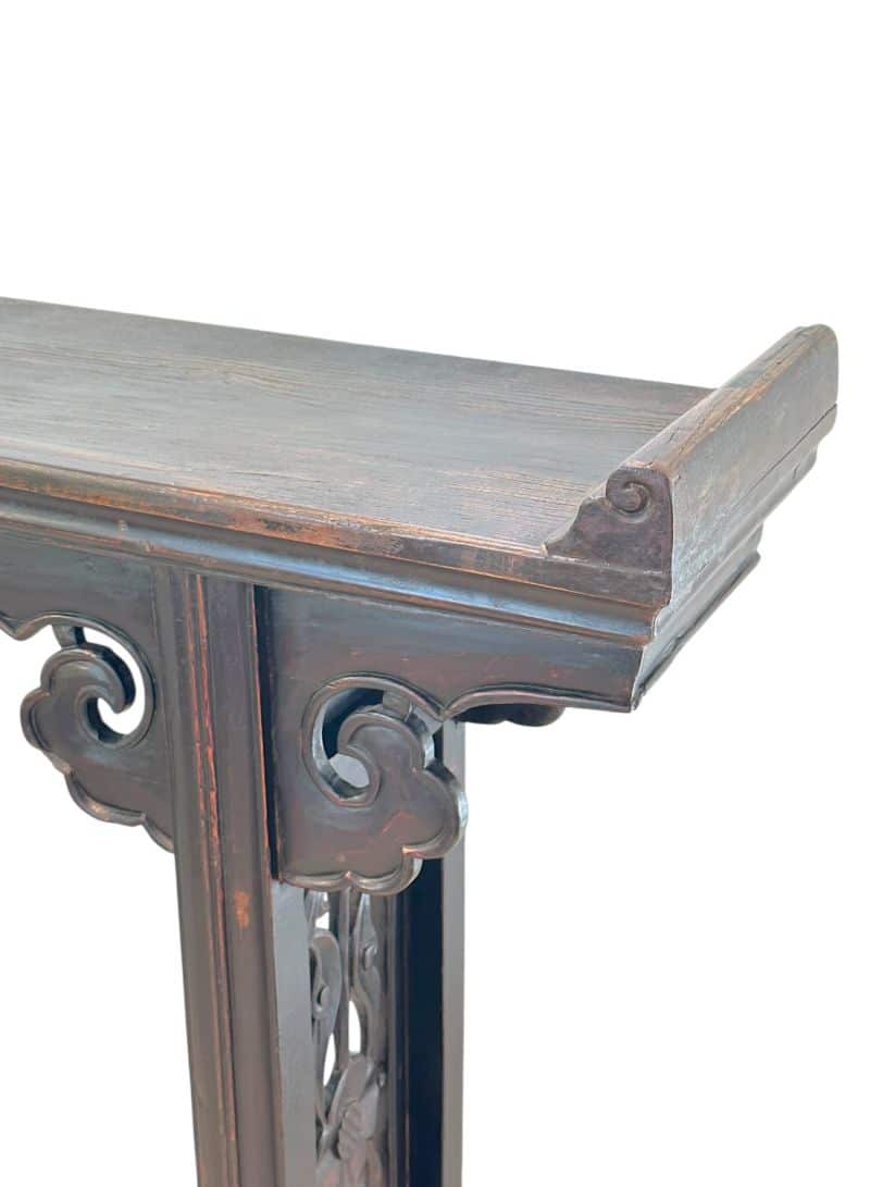 Aged wooden double sided console table with intricate carvings on legs and apron.