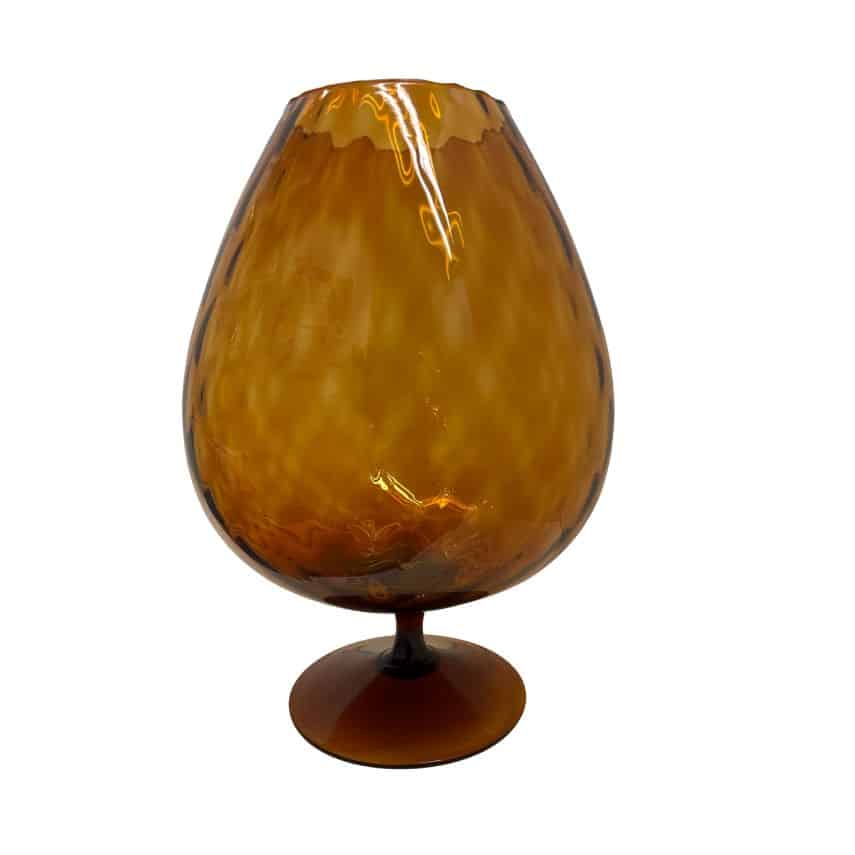 Close-up of vintage Italian Empoli amber vase with intricate patterns, reflecting light.