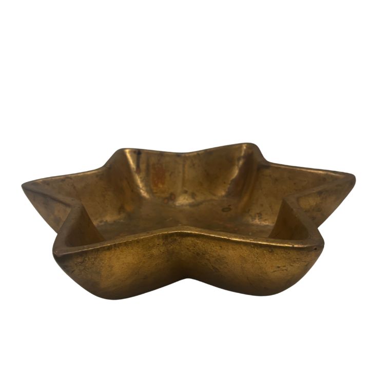 Close-up of an ornate vintage Italian porcelain bowl featuring a gold star motif with intricate details, circa 1980's.