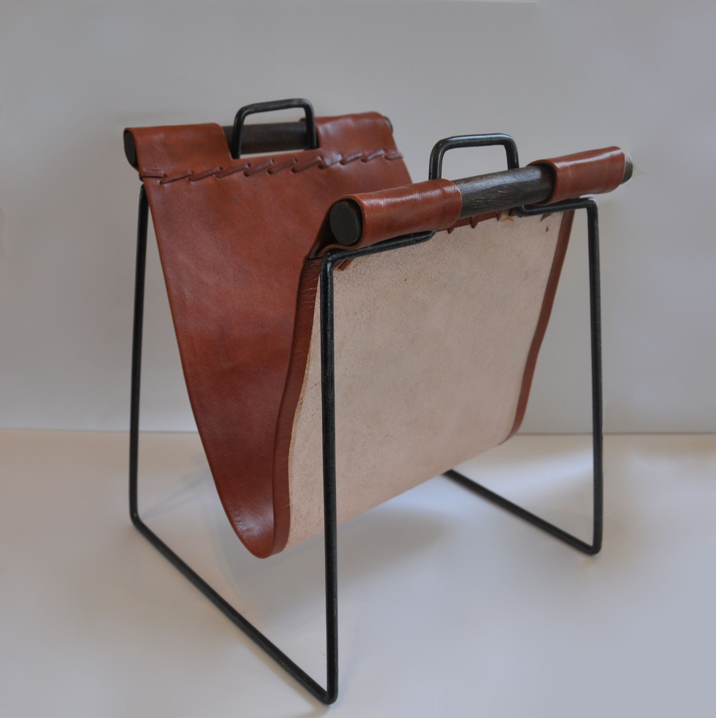Iron and leather magazine rack on a white background