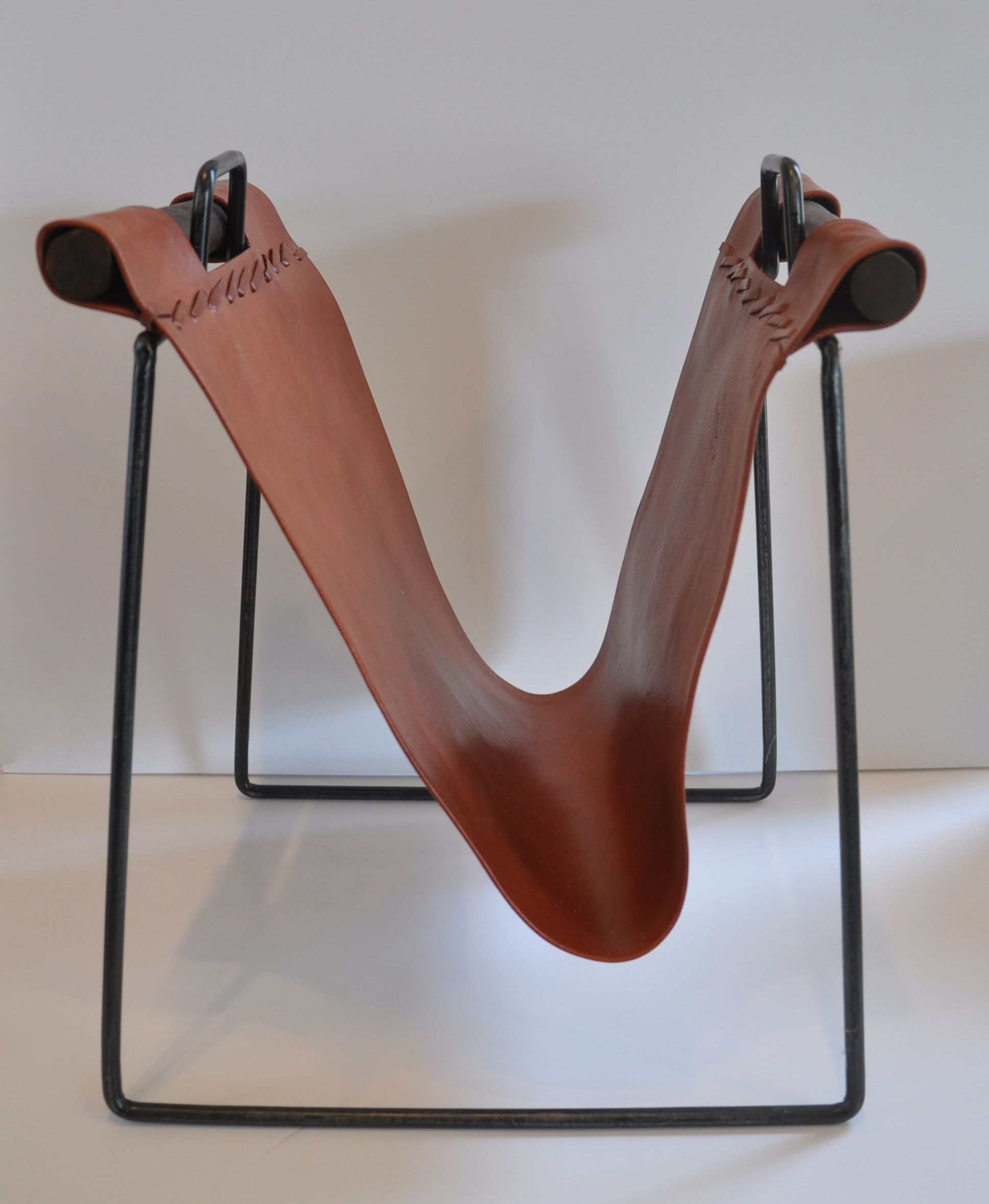 The image showcases a sleek and modern magazine rack crafted from iron and leather It s designed with two curved shelves each
