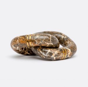 A marble chain with a brass inlay, coiled on a white background.