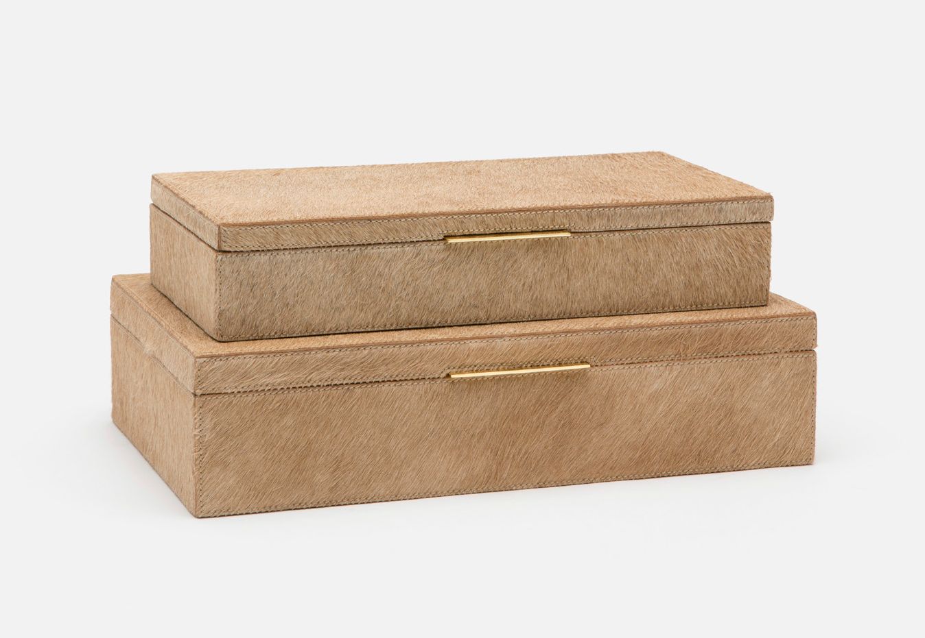 Two rectangular boxes with a hair-on hide finish and brass handles, one larger than the other, against a white background.