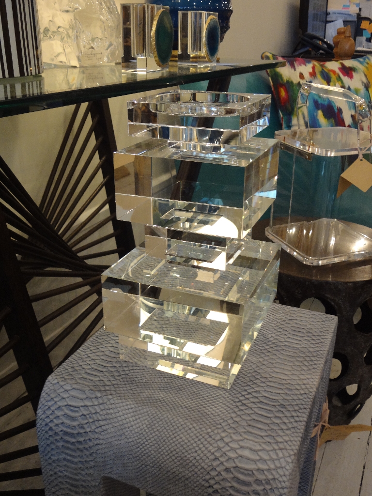 A large, clear crystal candle holder with a geometric design on display in a store.