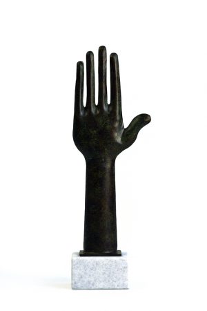Bronze hand sculpture on white stone base