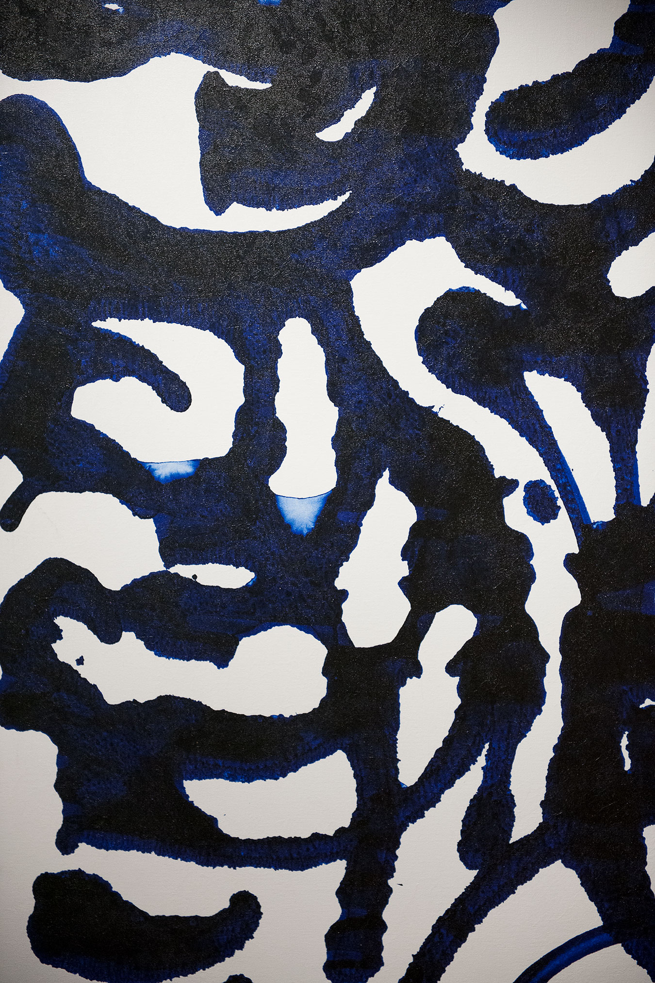 A black and white abstract art piece with blue hand embellishment.