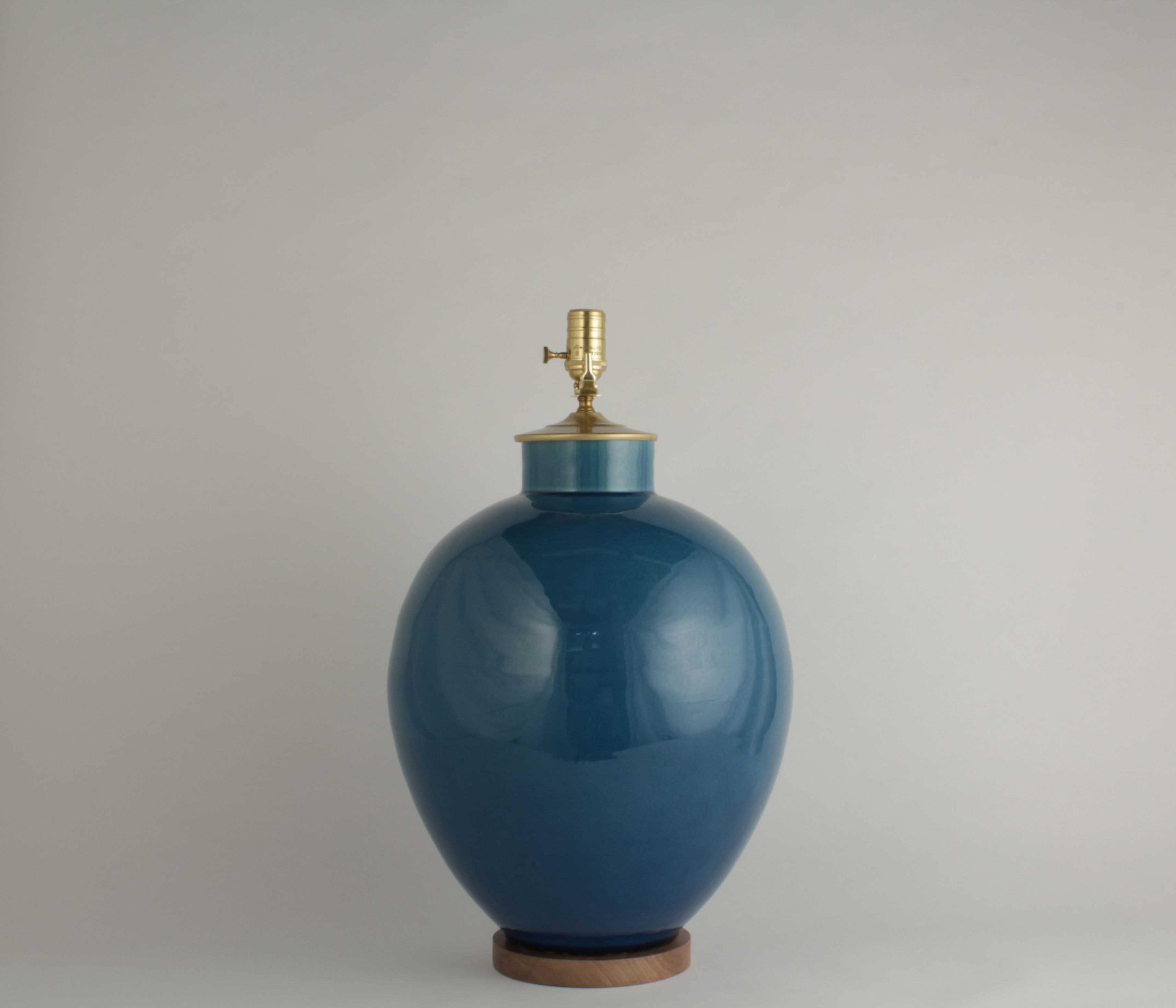 A blue ceramic lamp with a crackled finish on a white background.