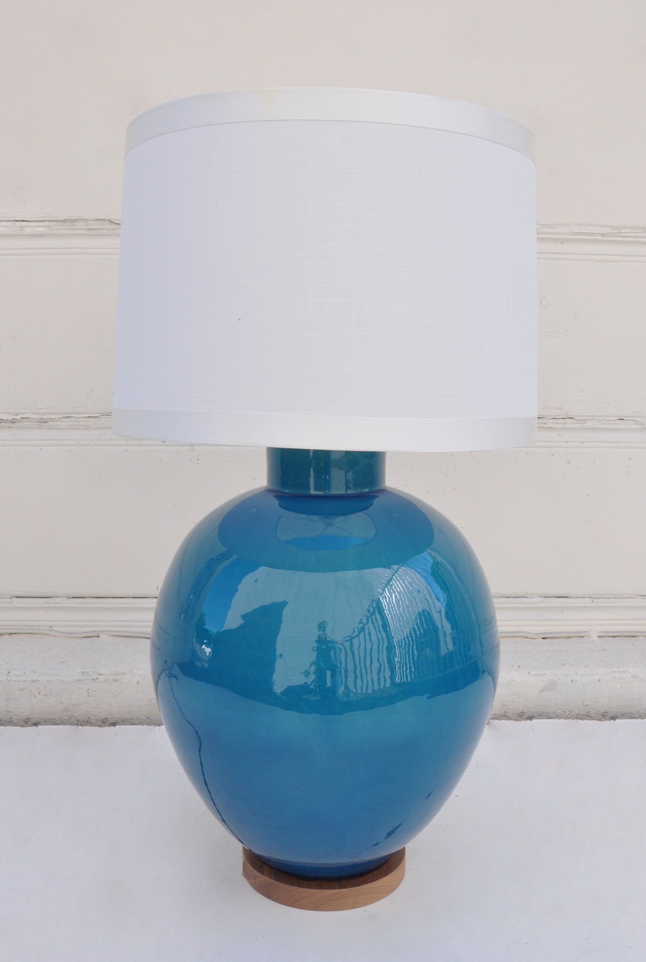 Blue lamp with white shade on a table