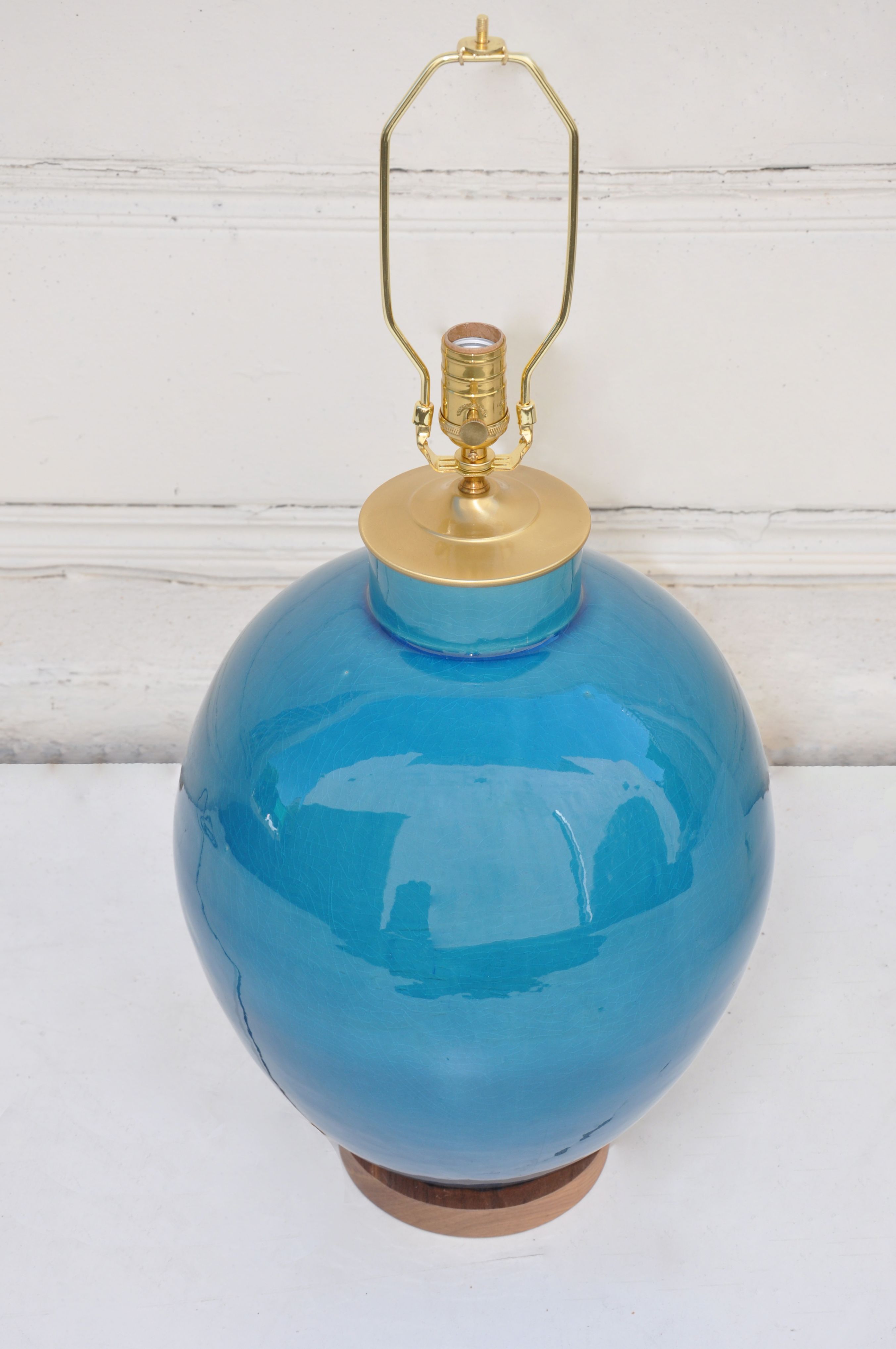 A blue ceramic lamp with a crackled finish and a copper-colored base.