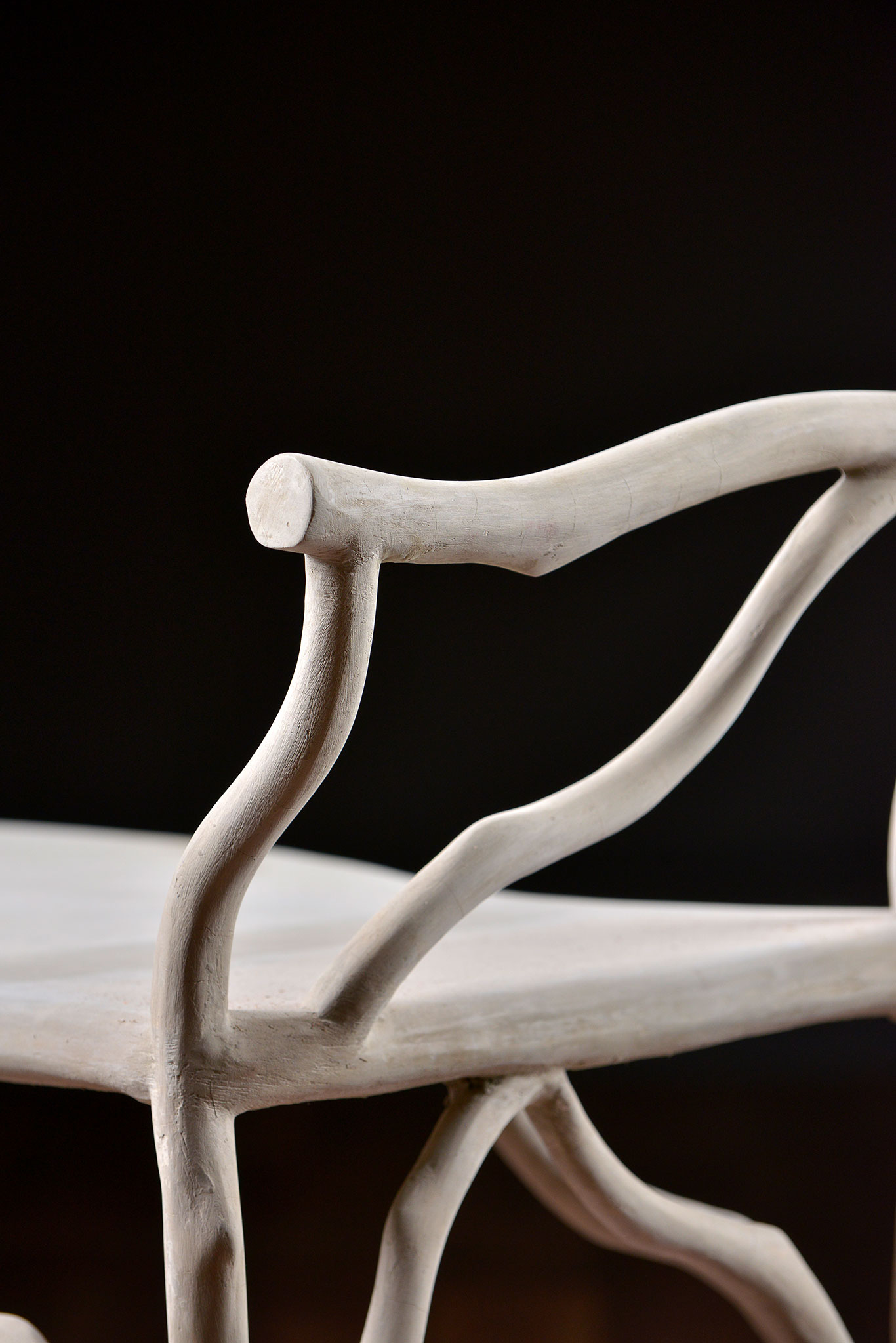 The image depicts a Faux Bois concrete bench with twig details, showcasing its natural color variations and hairline cracks.