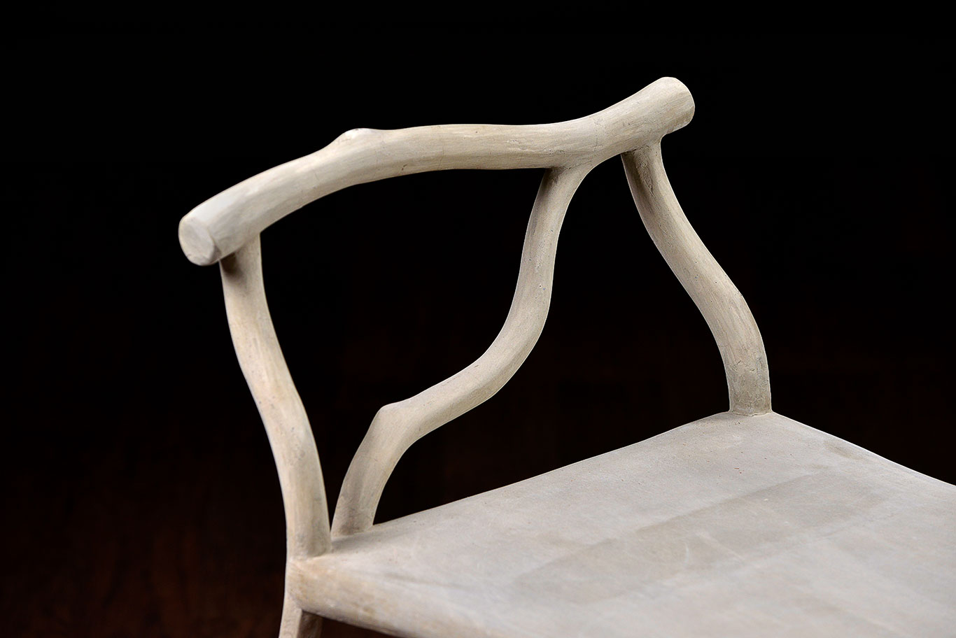 The image features a faux bois concrete bench with a unique design showcasing two curved branches as part of its structure It