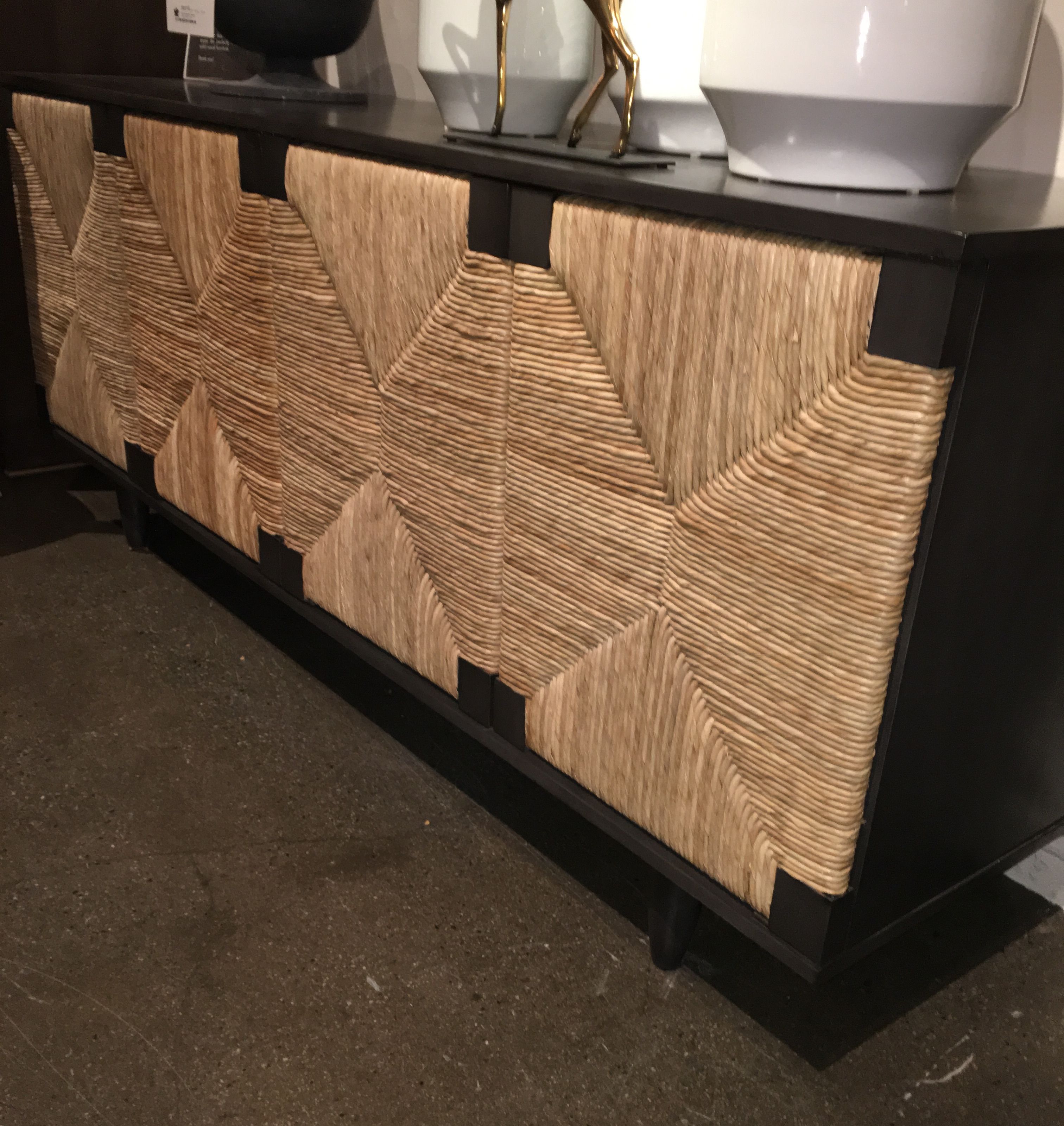 Black and brown buffet with woven top, in a room