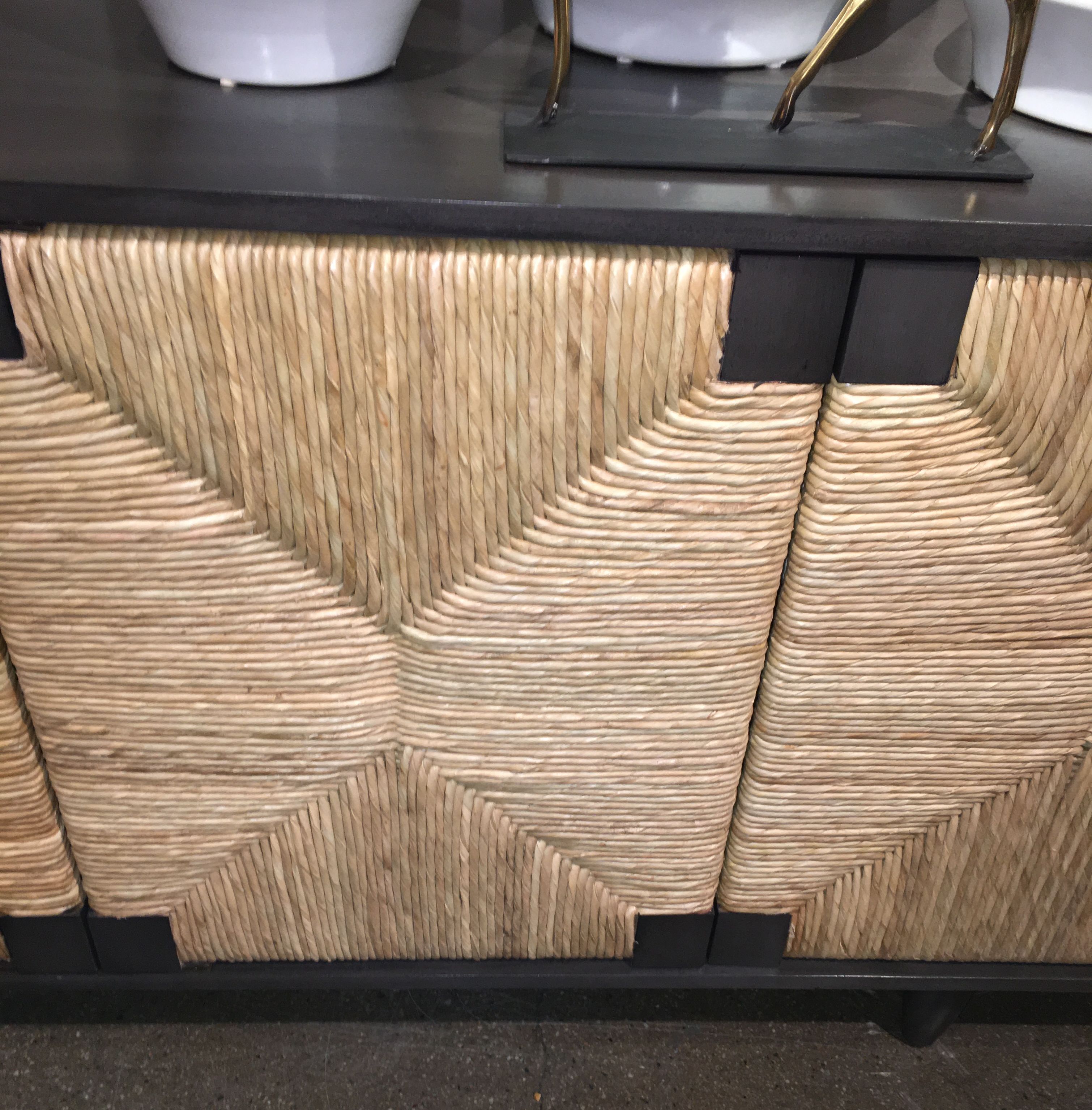 Small, dark brown buffet with four doors and a decorative woven front panel.