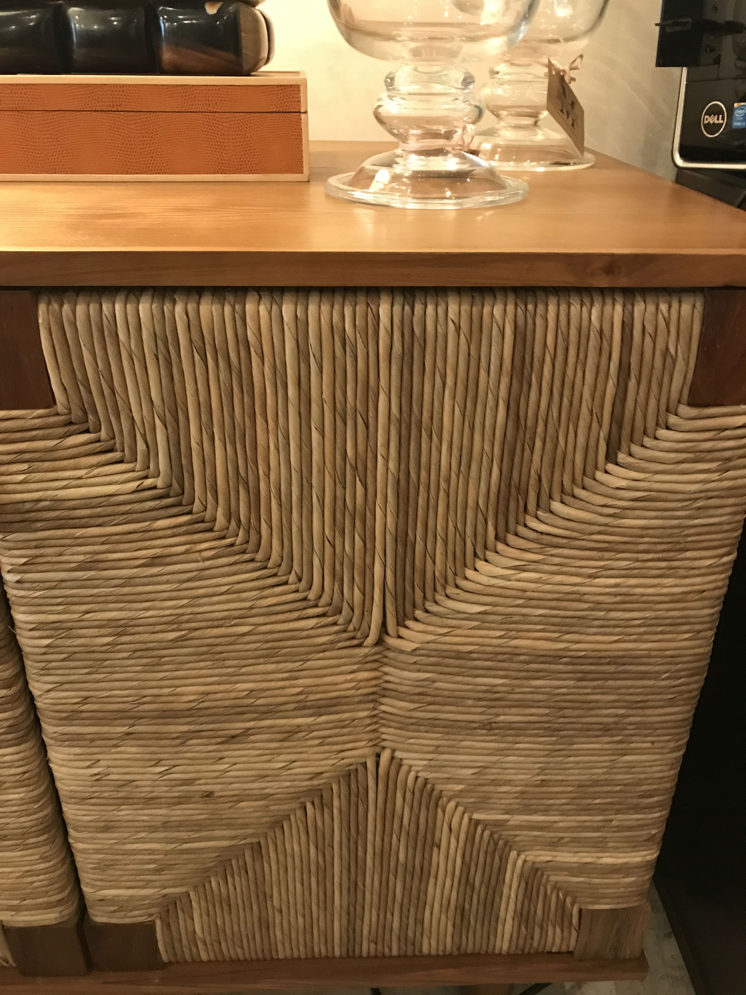 Two-door wicker buffet with a curved design, displayed on a wooden surface.