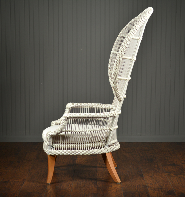 White wicker chair with teak legs and sunbrella seat pillow