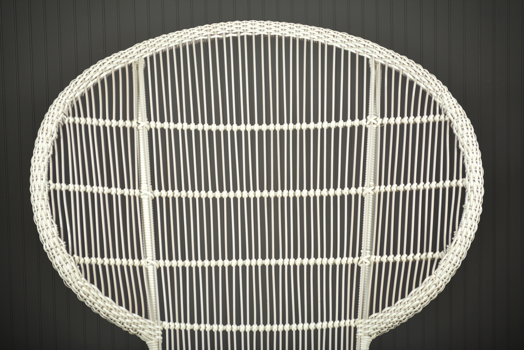 Outdoor chair with a lattice backrest and teak legs, available in brown, aged natural, or white rattan.