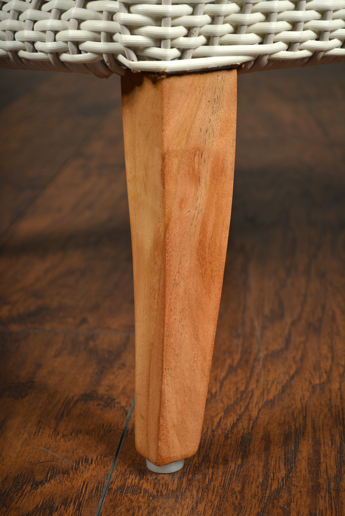 The image shows a close-up view of an Elizabethan Outdoor Chair with teak legs and a sunbrella seat pillow The chair is