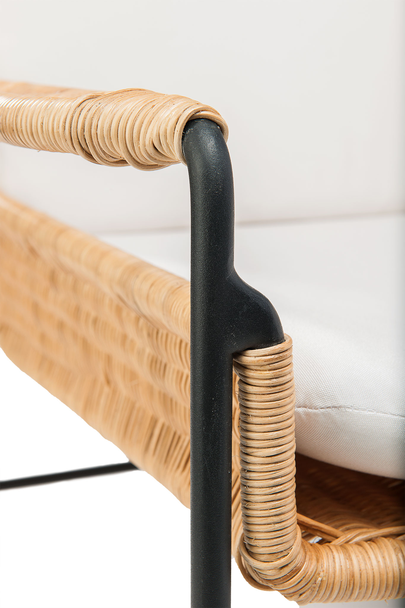 A wicker and metal club chair with a cushioned seat and backrest, displayed against a white background.