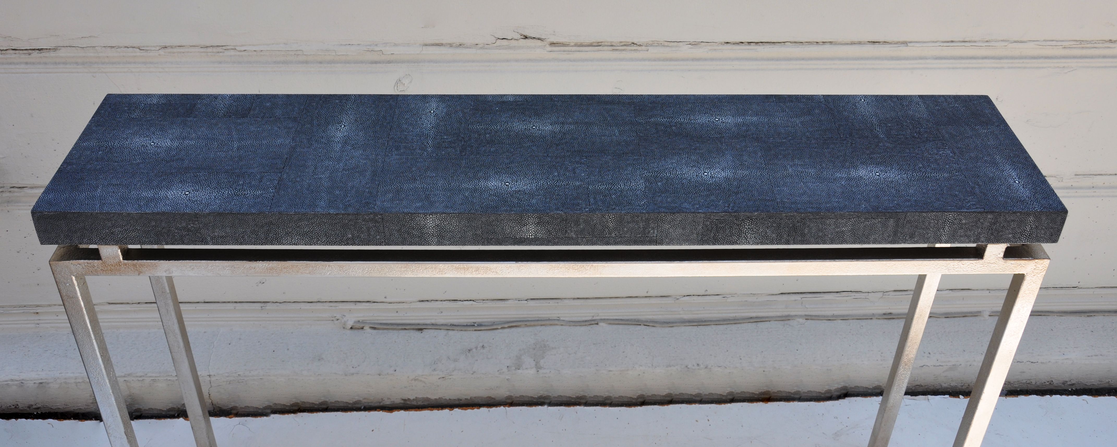 Small black console with a granite top and metal frame, featuring a clean lined design.
