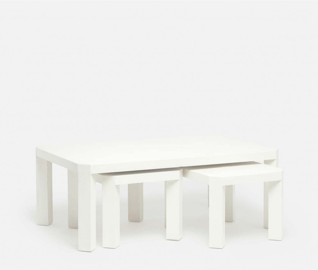 White nesting coffee table with angled legs available in two finishes pristine or seal faux raffia dimensions 52 L x 30 W