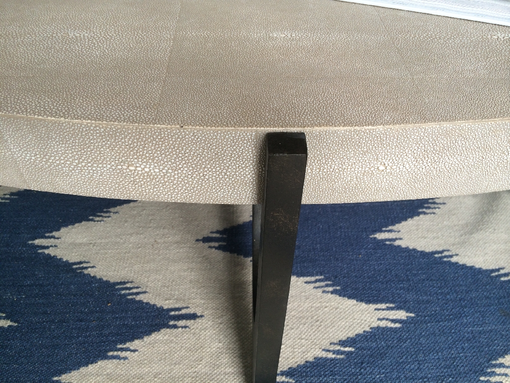 The image shows a Dominick Oval Faux Shagreen Coffee Table with a visible corner, indicating its unique design and material.
