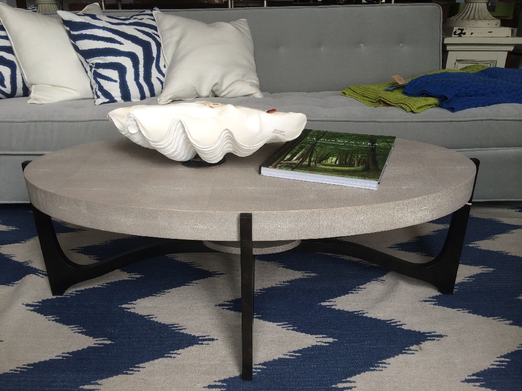The image showcases a stylish coffee table in a living room setting It has a unique oval shape and is adorned with